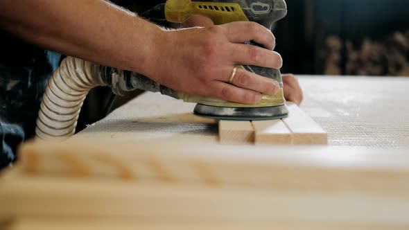 Man Using Electric Sander for wood in a carpentry workshop.Profession, carpentry, woodwork