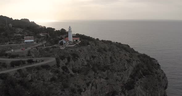 Aerial reverse, drone shot tilting away from the Far des Cap Gros lighthouse
