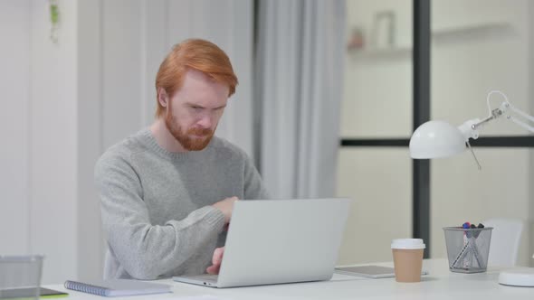 Redhead Man with Laptop Thinking at Work 