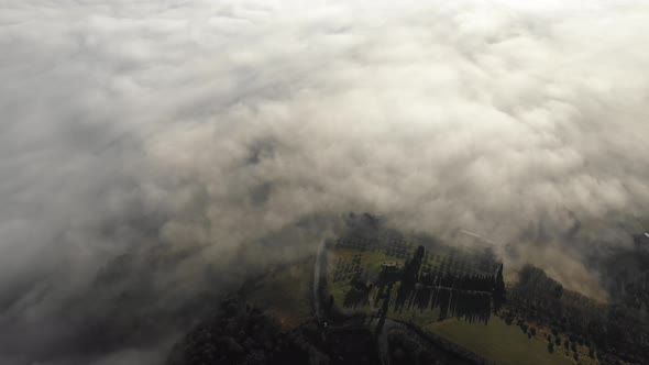 Aerial shot of morning fog over forest in Umbria, Italy