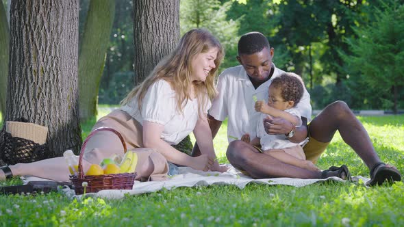 Black Father Fairskinned Mother and Mestizo Child in the Park