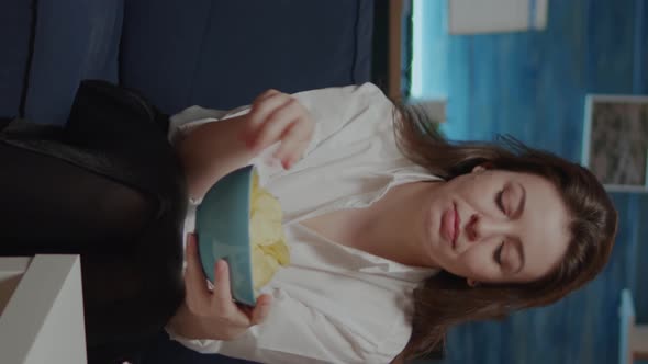 Vertical Video Portrait of Caucasian Woman Eating Chips From Bowl