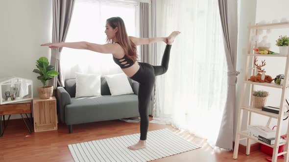 Lovely women in good shape with yoga exercise and stretching in the living room