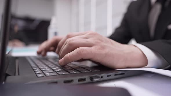 Closeup Side View Male Hands Typing on Laptop Keyboard in Slow Motion