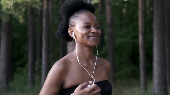 Running Black Woman in Sports Training with Headphones at Sunset on the Nature, Healthy Lifestyle