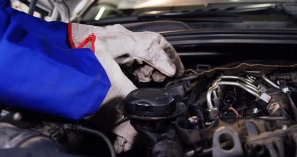 Hands of mechanic checking a car engine