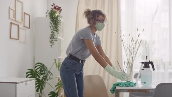 Sequence of Young Woman in Face Mask Disinfecting Surfaces