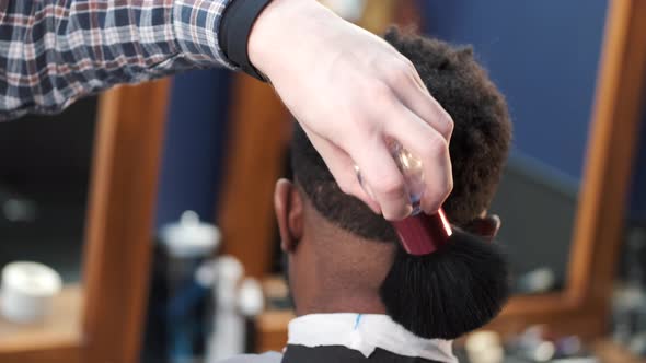 Barber Using Cleaninf Brush in a Salon