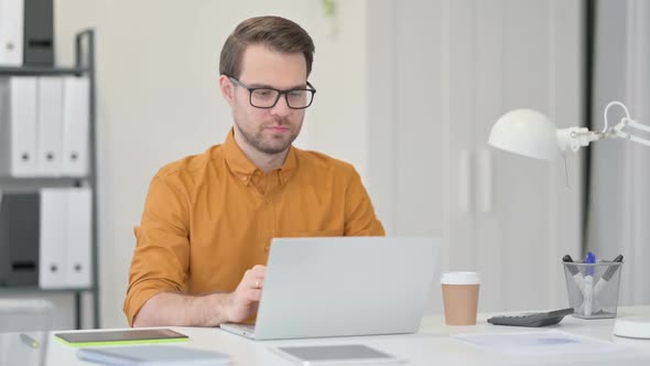 Excited Young Man Celebrating Win at Work