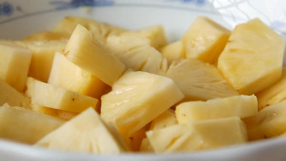 Slice of Pineapple in Bowl on Blue Background