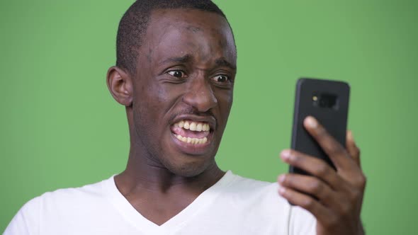 Young Angry African Man Shouting at Phone