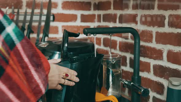 Woman Who Collects Purified Water in an Electric Kettle