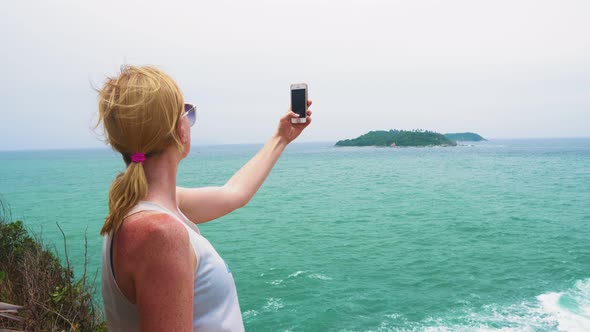 Girl Tourist Taking Pictures of The Sea and The Island on A Smartphone. Tropical Travel