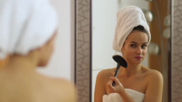 Young attractive woman with bath towel on her head and brush dances