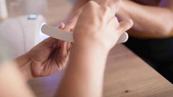 Tilt up video of woman during doing manicure. Shot with RED helium camera in 8K.