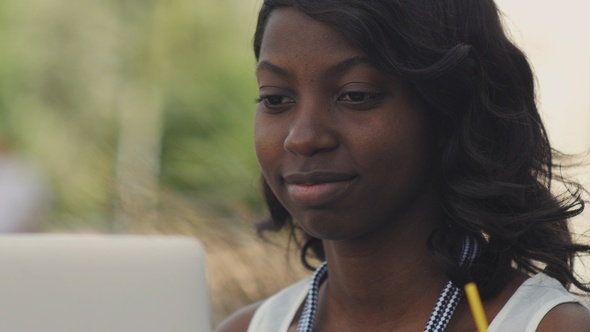 Beautiful woman having video chat on laptop computer outsite