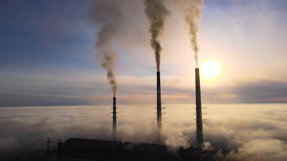 Aerial View of Coal Power Plant High Pipes with Black Smoke Moving Up Polluting Atmosphere at Sunset