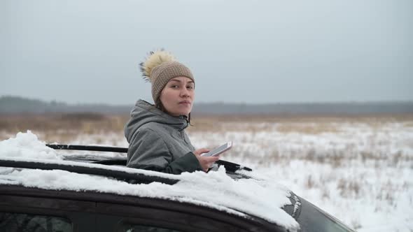 Woman driver got lost in a snow-covered field and looked out the hatch of a car