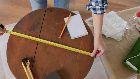 Woman with Ruler Measuring Table for Renovation