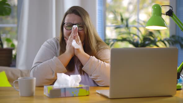 Obese Woman Working From Home Feeling Sick and Sneezing in Tissue