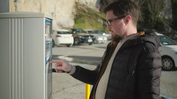 Man Is Using Parking Meter, Pressing Buttons