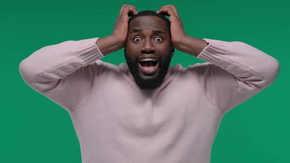 Shocked African American Guy with Open Mouth Holding His Head on Green Screen Chroma Key