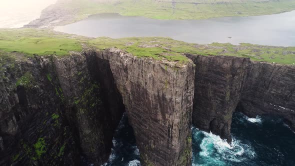 Aerial view of tourists English Slave cliff on North Atlantic sea, Faroe island.