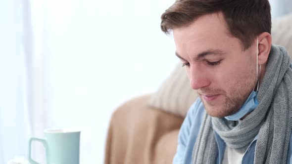 Man Curing at Home and Putting on Mask While Selfisolation