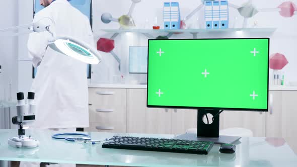 Dolly Shot of Green Screen Monitor on Desk in Modern Research Facility