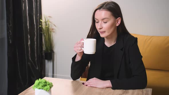 Satisfied Businesswoman Drinking Tea at Home Office