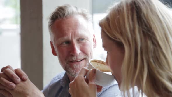 Couple in a cafe talking and enjoying their cappuccino