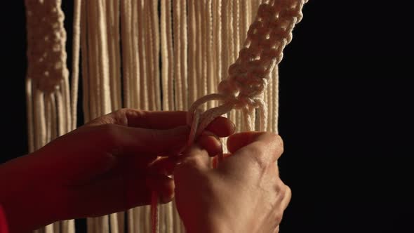 Women's Hands Weave a Macrame Pattern in Creative Workshop on Black Background