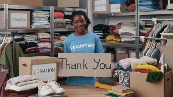 Portrait View of the Diverse Female Volunteer Holding Cupboard Banner with Thank you Phrase and