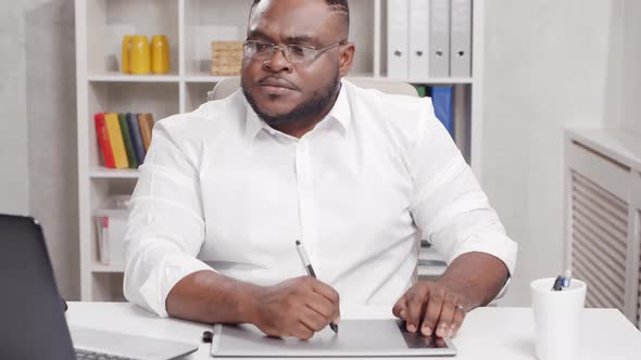 Workplace of freelance worker at home office. Young African-American man.