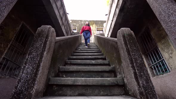 Cheerful woman walking down steps of old house