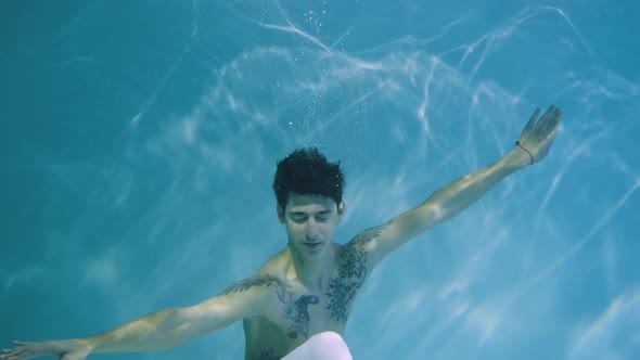 Underwater Shot of Man with a Halfnaked Torso Gracefully Dancing Modern Ballet Choreography