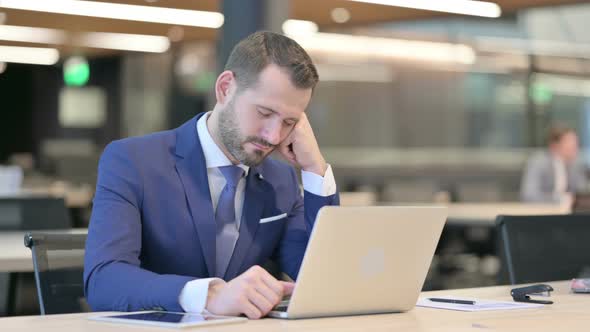 Middle Aged Businessman Taking Nap At Work