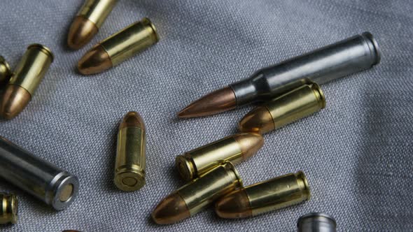 Cinematic rotating shot of bullets on a fabric surface - BULLETS 091