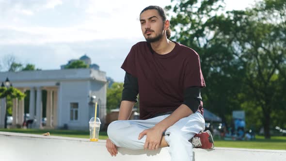 Closeup Portrait of Handsome Arab Man Sitting in the Park and Drinking Coffee Tonic