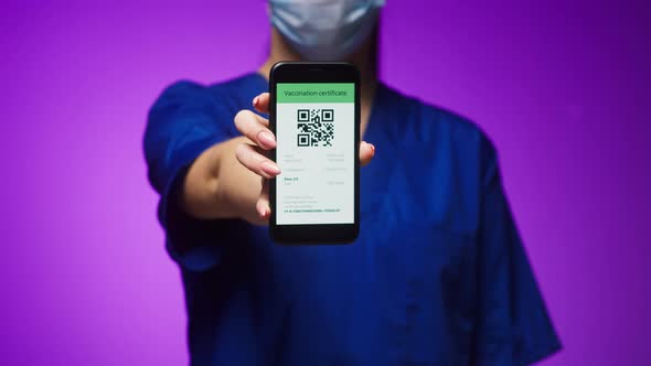 Woman Surgeon in Medical Uniform Showing Vaccination Passport with Qr Code on Phone International