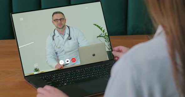Woman Video Chatting with Doctor. Tele Medicine Check Up From Home on Laptop Over the Internet. Girl