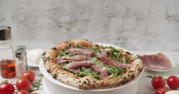 Delicious Pizza with Prosciutto Parma Ham Arugula Salad Rocket with Ingredients