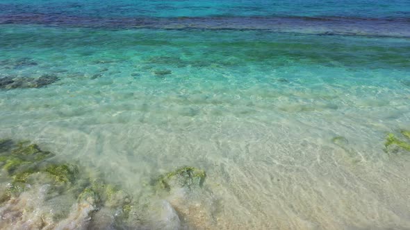 Beautiful sea bottom with rocks on white sand and green algae under clear crystal water of turquoise