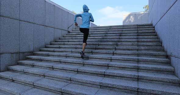 Fitness sports woman running up stairs in city