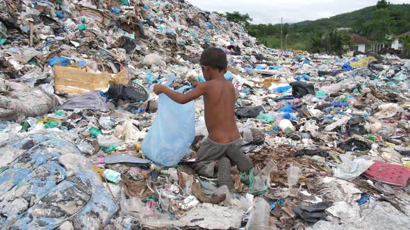 Poor Boy Collects Items To Recycle On A Garbage Dump alt