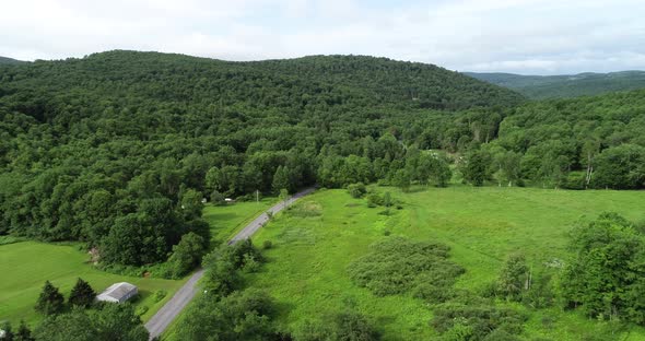 A car rolls down a road toward the overlapping mountains in the landscape of the Catskill Mountains