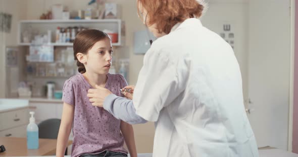 Female doctor checking a young girl in the clinic