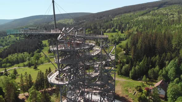 Aerial orbit over the observation tower located in the middle of the forest in Sudety mountains