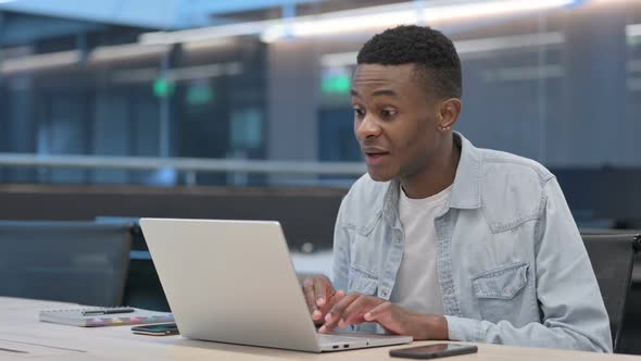 Successful African Man Celebrating on Laptop at Work