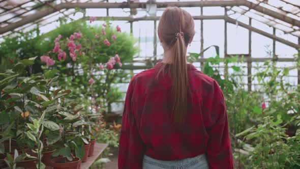 Blonde Girl Goes to Work on a Flower Greenhouse